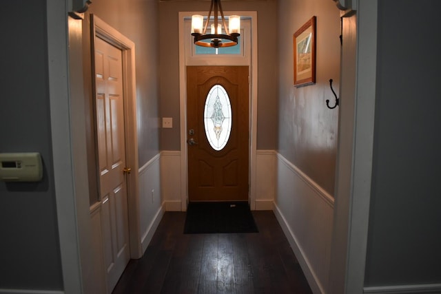 doorway with dark hardwood / wood-style floors and a notable chandelier