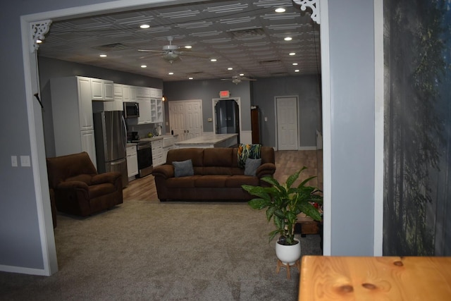 living room featuring ceiling fan and carpet