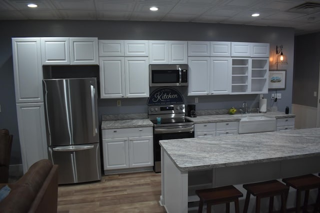 kitchen featuring light hardwood / wood-style floors, sink, white cabinetry, and appliances with stainless steel finishes