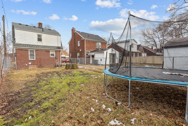 view of yard with a trampoline and fence