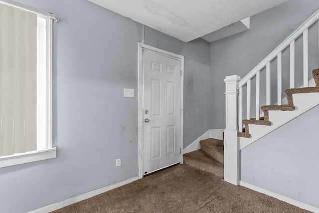 foyer featuring stairs, carpet floors, plenty of natural light, and baseboards