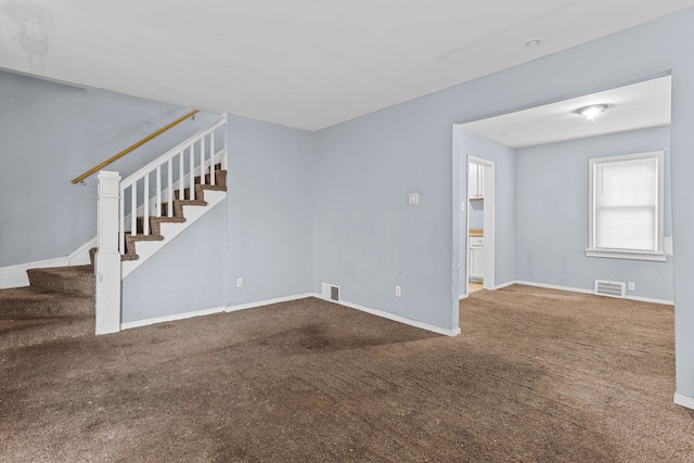 empty room featuring baseboards, visible vents, stairway, and carpet flooring