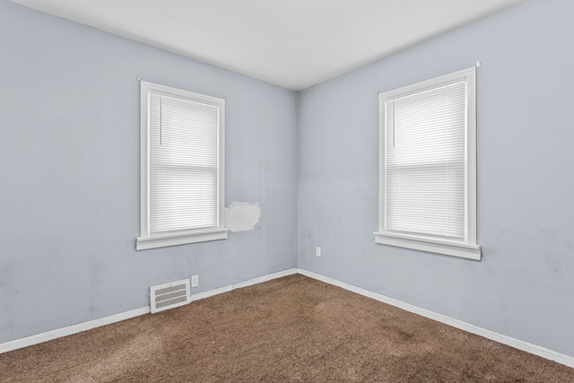 carpeted spare room with baseboards and visible vents