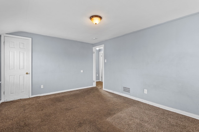 carpeted spare room with lofted ceiling, visible vents, and baseboards