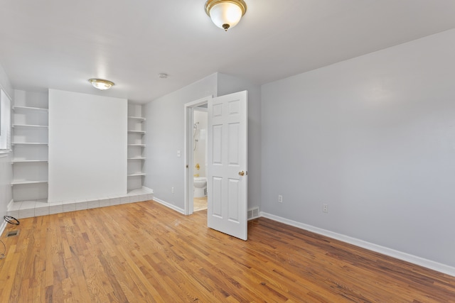 interior space featuring visible vents, baseboards, and wood finished floors