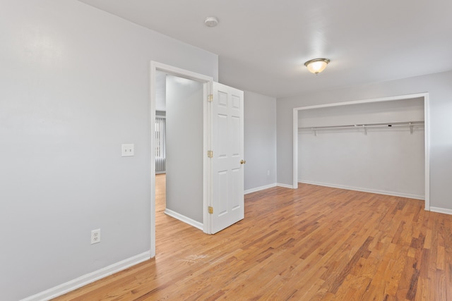 unfurnished bedroom featuring a closet, baseboards, and light wood-style floors