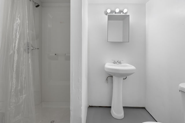 bathroom with a stall shower and toilet