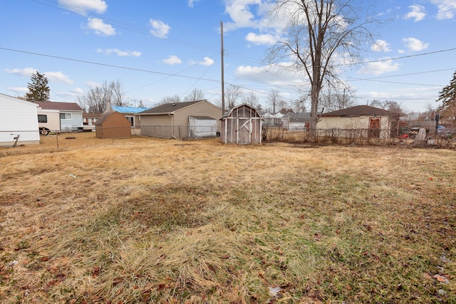 view of yard with an outdoor structure, fence, and a shed