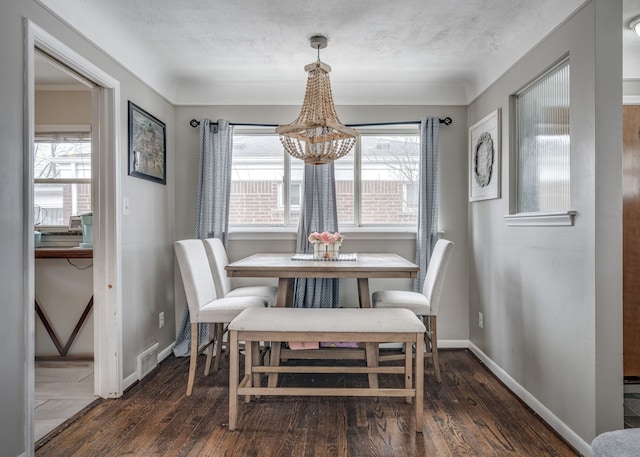 dining space featuring dark wood-type flooring and a textured ceiling