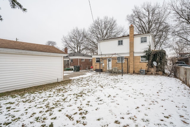 snow covered back of property featuring cooling unit