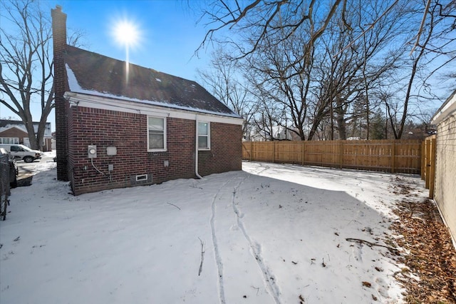 view of snow covered rear of property