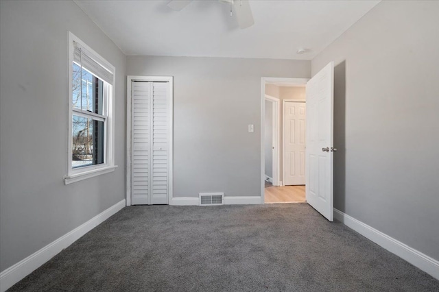 unfurnished bedroom with ceiling fan, carpet floors, and a closet