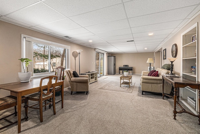 carpeted living room with a paneled ceiling