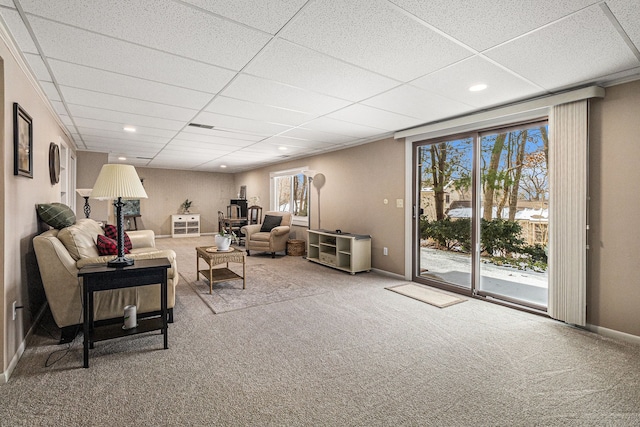 carpeted living room with a paneled ceiling