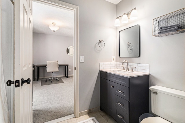 bathroom with toilet, tasteful backsplash, and vanity