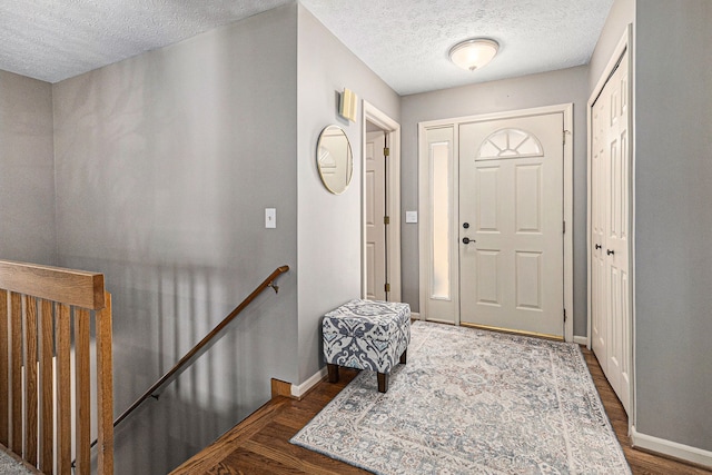 entryway featuring a textured ceiling and dark hardwood / wood-style flooring