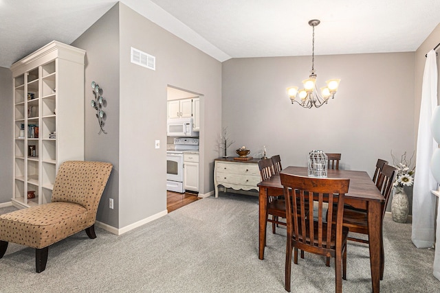 carpeted dining room featuring vaulted ceiling and an inviting chandelier