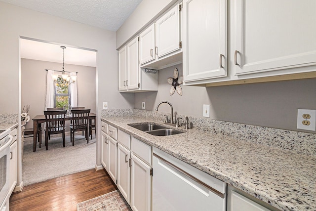 kitchen with sink, hanging light fixtures, light stone countertops, dark wood-type flooring, and white cabinets