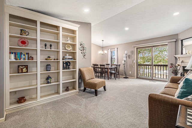 carpeted living room with a textured ceiling, a chandelier, lofted ceiling, and built in shelves