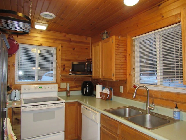 kitchen with sink, white appliances, wooden walls, and wood ceiling