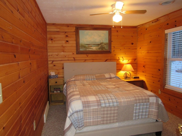 bedroom featuring wood walls, carpet flooring, and ceiling fan