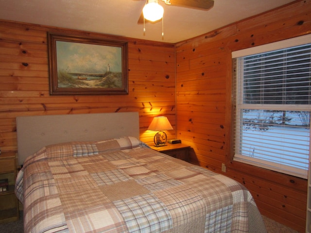 bedroom featuring wooden walls and ceiling fan