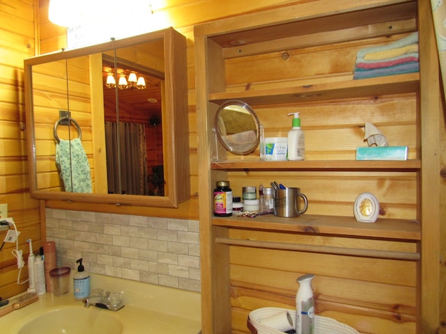 bathroom featuring sink, a chandelier, and tasteful backsplash