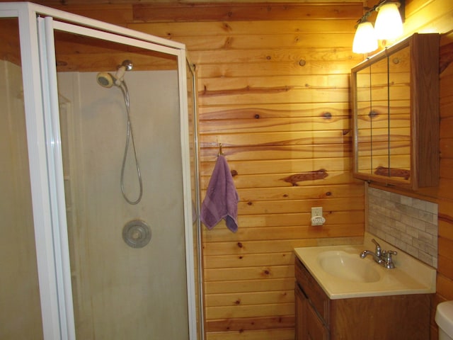 bathroom featuring a shower with shower door, toilet, vanity, and wood walls