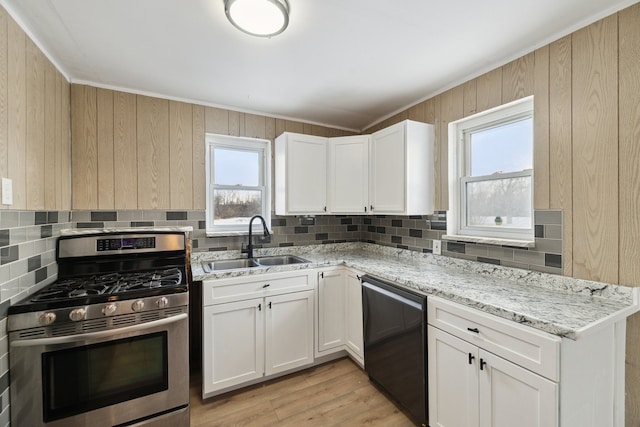 kitchen featuring sink, gas stove, light stone counters, light hardwood / wood-style floors, and white cabinets