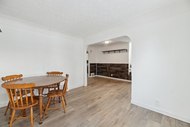 dining room with light hardwood / wood-style flooring and a textured ceiling