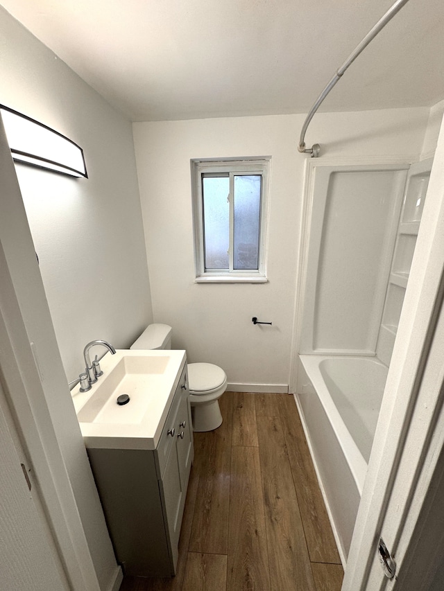 full bathroom featuring wood-type flooring, toilet, shower / washtub combination, and vanity