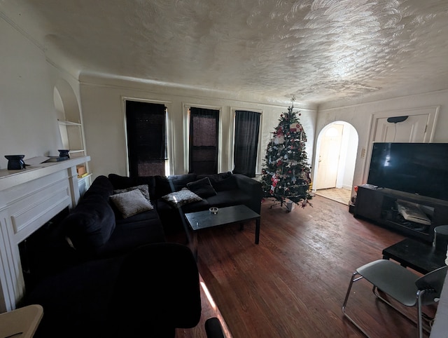 living room with a textured ceiling, hardwood / wood-style floors, and a fireplace