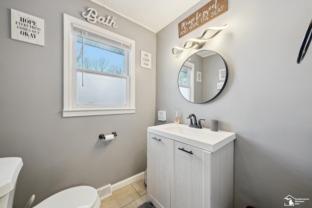 bathroom with toilet, vanity, and tile patterned floors