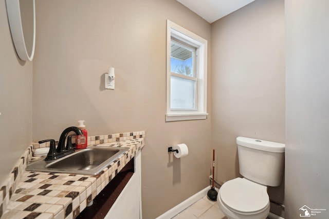 bathroom featuring sink, toilet, and tile patterned flooring