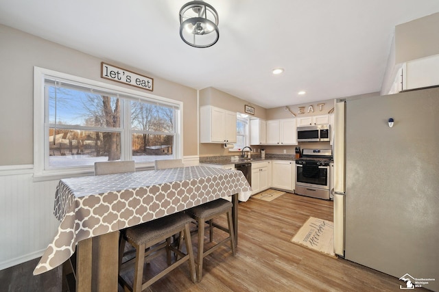 kitchen featuring white cabinets, light wood-type flooring, sink, and stainless steel appliances