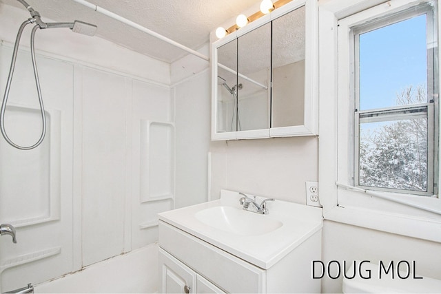 bathroom with vanity, a textured ceiling, and washtub / shower combination