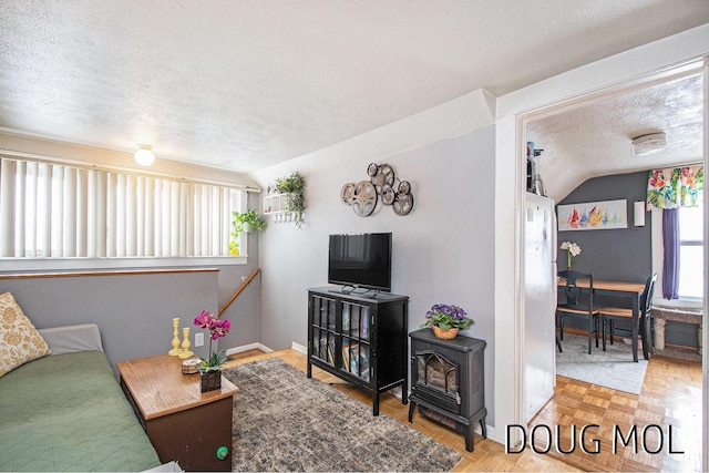 living room with parquet flooring, a wealth of natural light, a textured ceiling, and vaulted ceiling