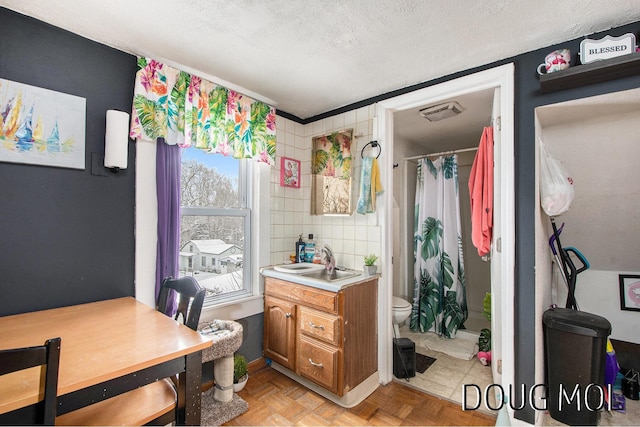 bathroom featuring toilet, parquet floors, a textured ceiling, vanity, and curtained shower