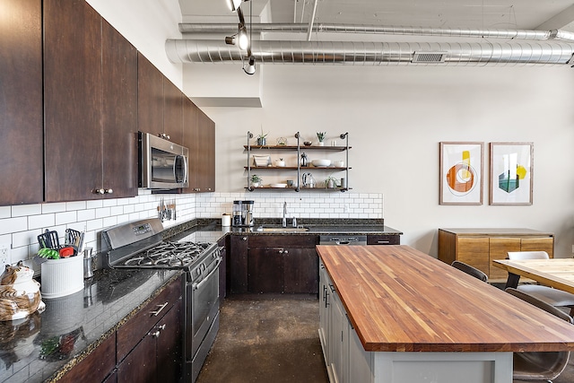 kitchen with tasteful backsplash, sink, stainless steel appliances, and wood counters