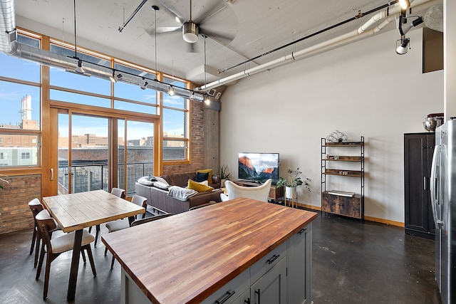 interior space with ceiling fan and stainless steel refrigerator