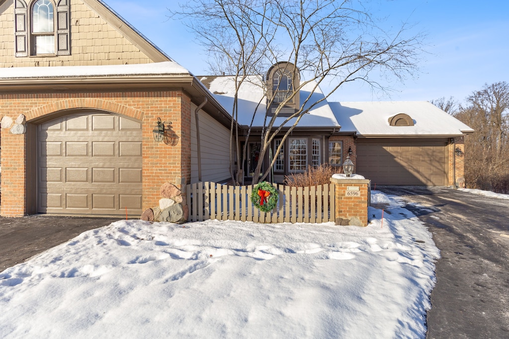 snow covered property with a garage