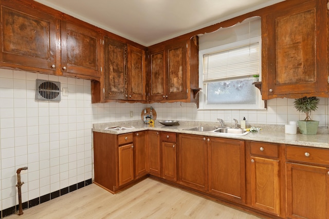 kitchen featuring sink, light stone countertops, and light hardwood / wood-style floors