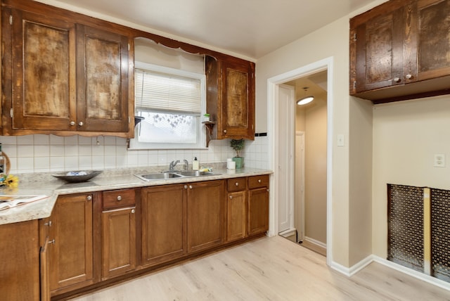 kitchen featuring light hardwood / wood-style floors, sink, and tasteful backsplash