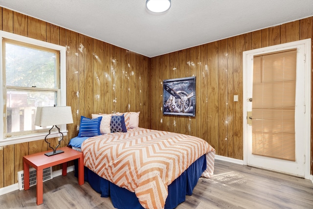 bedroom featuring wooden walls and wood-type flooring