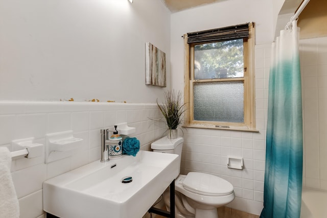 bathroom featuring sink, tile walls, and toilet