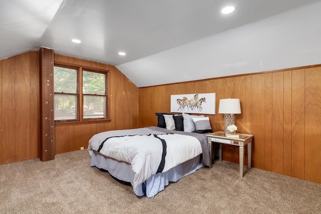 carpeted bedroom with wooden walls and vaulted ceiling