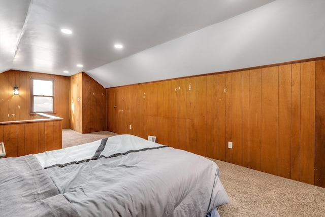 carpeted bedroom featuring wooden walls and vaulted ceiling