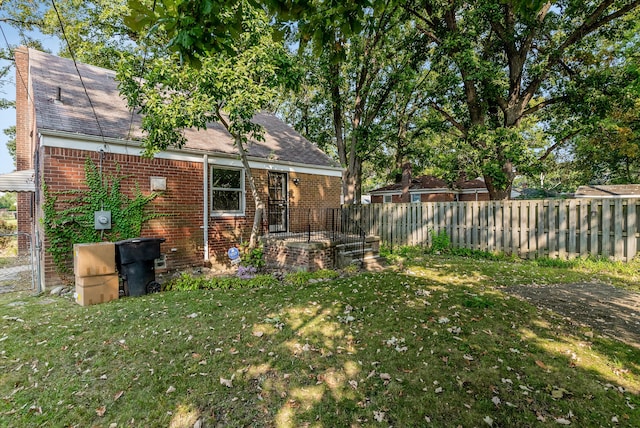 rear view of property featuring a lawn