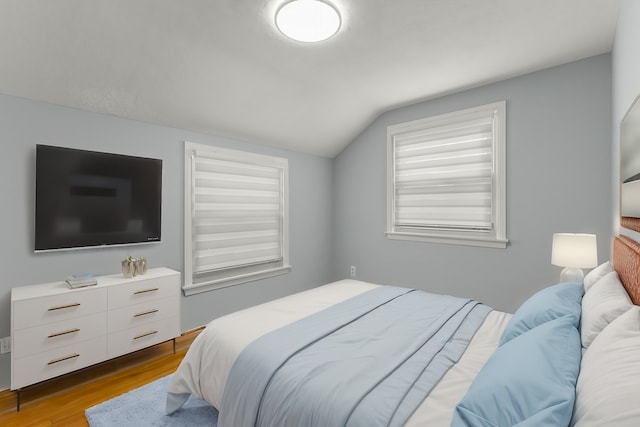 bedroom with light hardwood / wood-style flooring and lofted ceiling