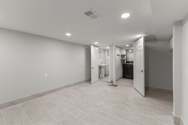 interior space with sink, light tile patterned floors, and washer / clothes dryer